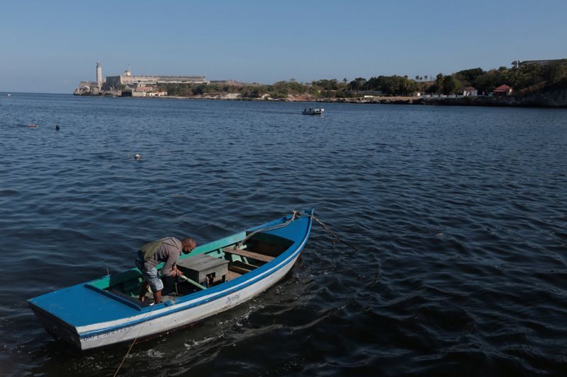 a-fisherman-works-in-his-boat-in-havana